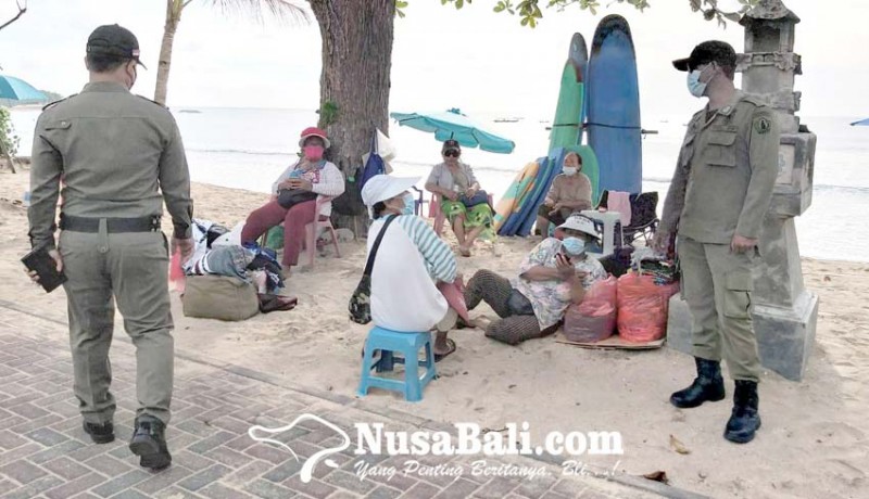 www.nusabali.com-gunakan-masker-di-dagu-pedagang-pantai-kuta-kena-semprit