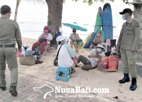 Nusabali.com - gunakan-masker-di-dagu-pedagang-pantai-kuta-kena-semprit