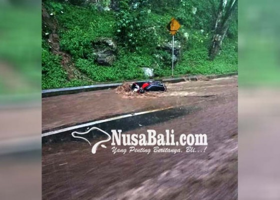 Nusabali.com - bebatuan-terbawa-arus-banjir-pengendara-motor-pilih-menepi