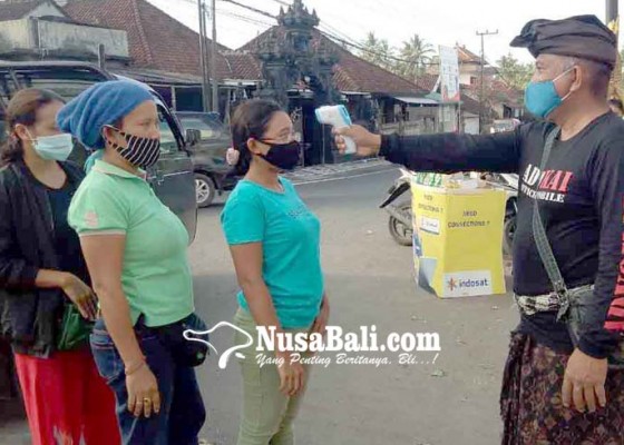 Nusabali.com - pecalang-cek-suhu-tubuh-pengunjung-pasar-ulakan